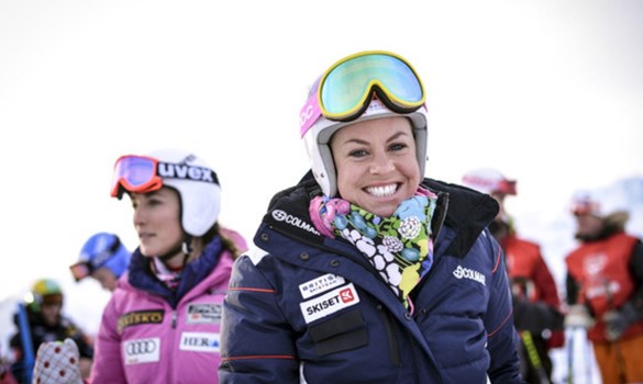 Female skiiers smiling wearing ski gear, goggles pulled up